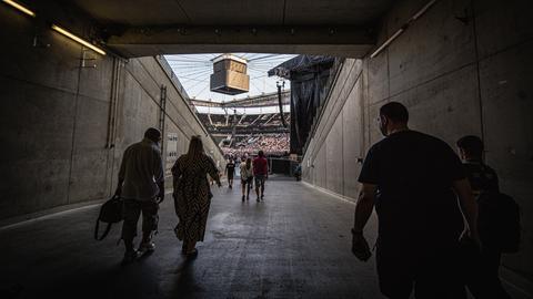 Fans gehen durch einen Tunnel unter der Tribüne in den Innenraum des Stadions.