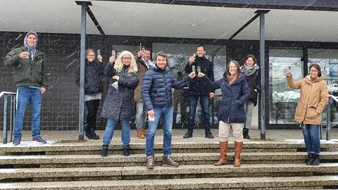 Das Frühteam mit einem Glas Sekt vor dem hr4-Studio in Kassel.