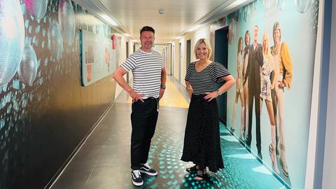 Britta Wiegand und Peter Küstern tragen schwarz-weiß getreifte Shirts und einen schwarzen Rock bzw. eine schwarze Hose