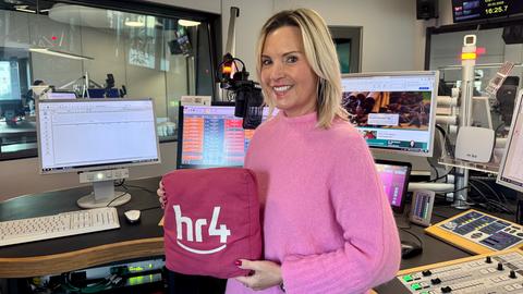 Britta Wiegand mit pinkem Shirt und dem pinken hr4-Kissen