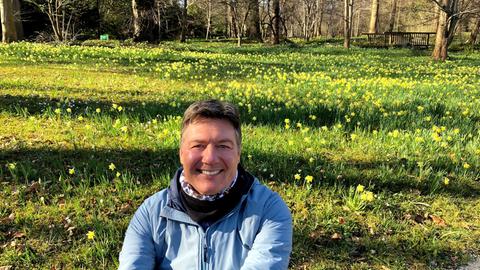 Dieter Voss botanischen Garten in Frankfurt mit blühenden Osterglocken im Hintergrund