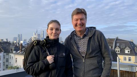 Schornsteinfegerin Xenia Schuhmann und Dieter Voss vor der Frankfurter Skyline