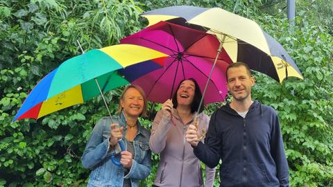 Katja Metz, Inka Gluschke und Julian Jack mit Regenschirmen