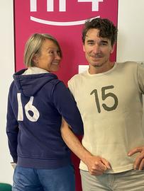 Katja Metz trägt einen Hoodie mit der 16 auf dem Rücken und Uwe Becker ein T-Shirt mit der 15 auf der Brust.