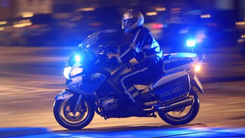Polizist auf einem Motorrad im nächtlichen Frankfurt