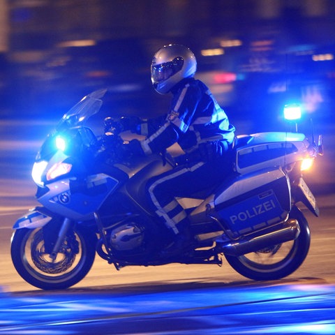 Polizist auf einem Motorrad im nächtlichen Frankfurt