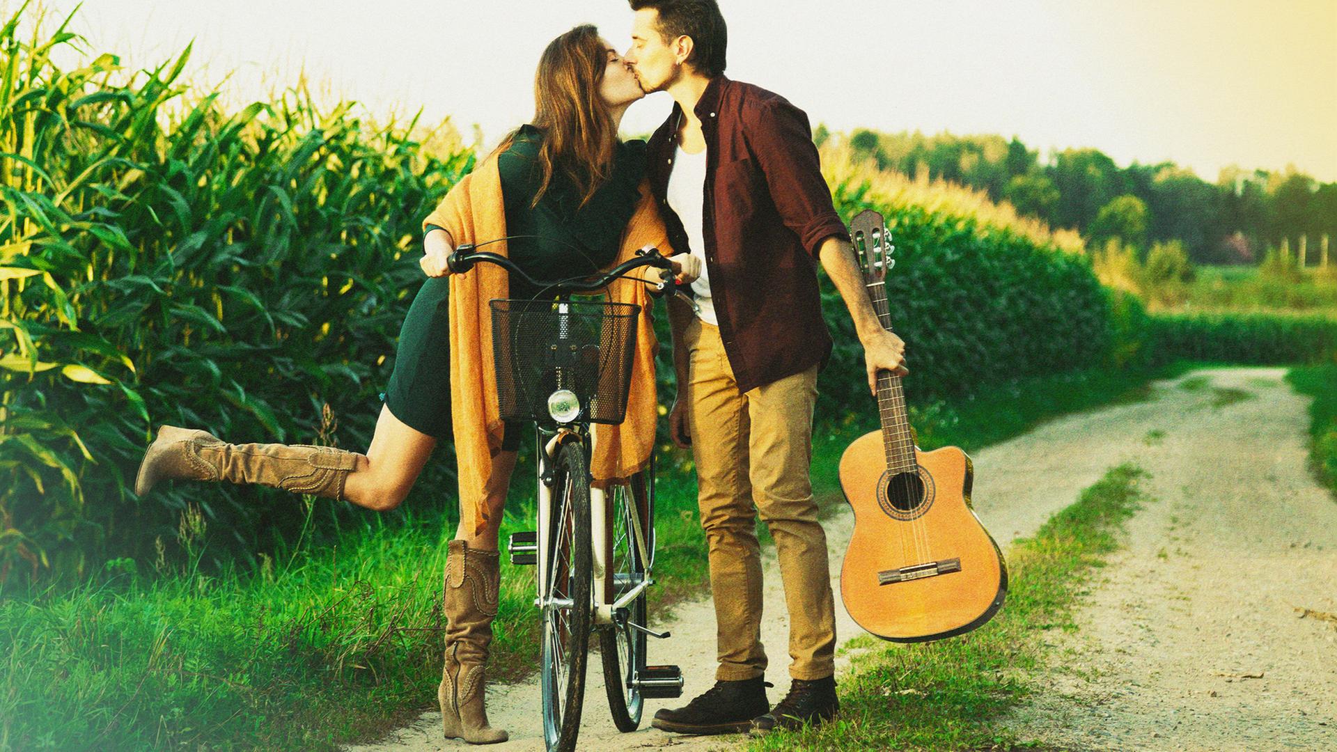 Girl riding guy. Guy and girl on a distance. Guy and girl far. A guy holding Guitar on Shoulders.