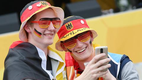 Zwei junge Männer in deutschen Fan-Utensilien machen ein Selfie